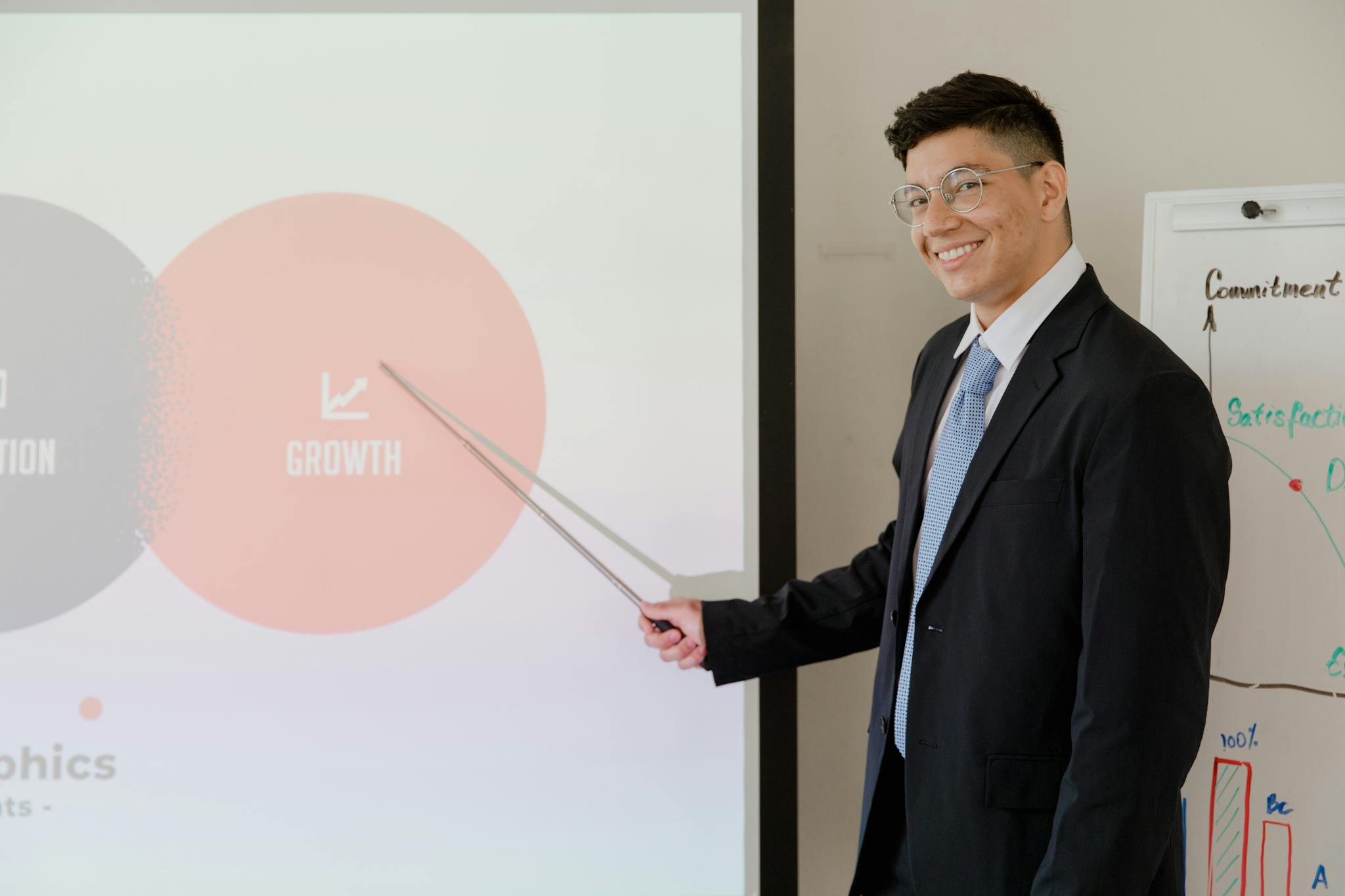 Smiling businessman presenting growth strategy in a modern meeting room.